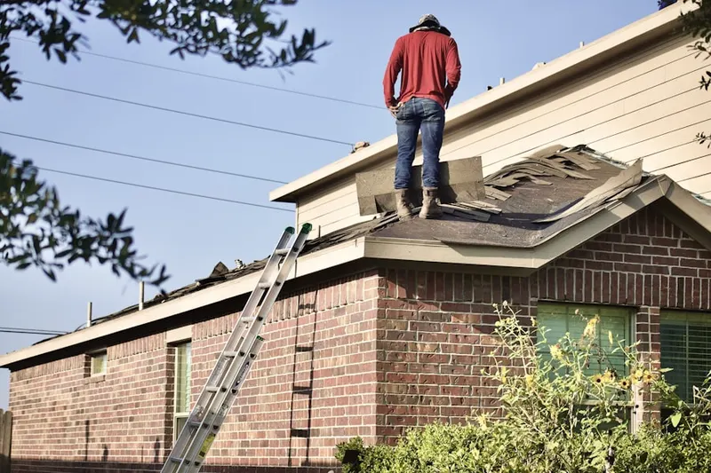 Professional roofer working on a residential roof in Stratton Capers
